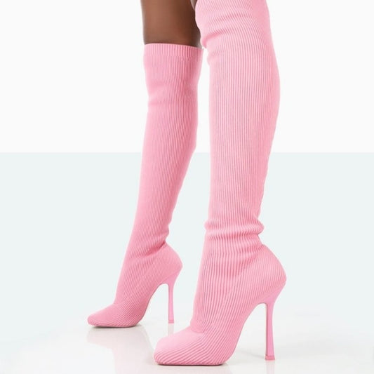 Pink knee-high boots with high heels on a white background